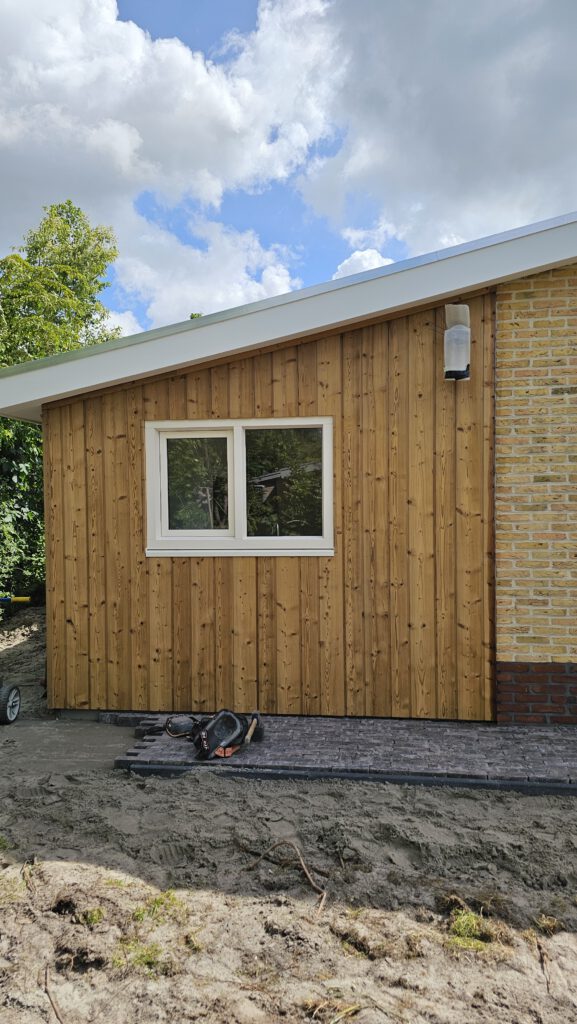 Oude gevelbekleding woning voor renovatie met verouderde houten delen